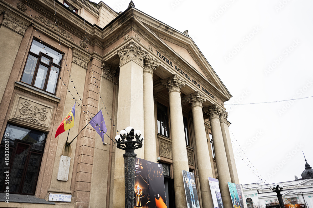 Fototapeta premium Mihai Eminescu National Theatre building in Chisinau Moldova with columns flags and banners in front
