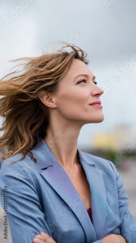 A woman confidently gazes into the distance, hair blowing in the wind.