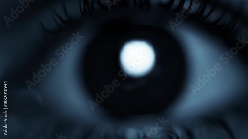 A close-up view of a human eye with a glowing pupil in a dark environment