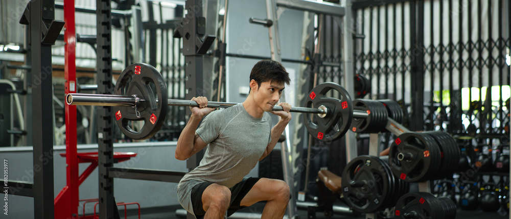 Obraz premium A man doing a squat and lifting weights