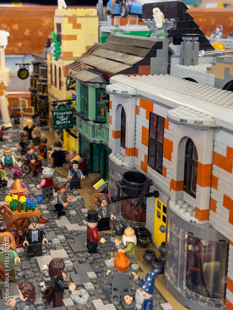 Fototapeta premium LEGO display of Diagon Alley, shops like Flourish and Blotts from the Harry Potter universe, cobblestone streets, and numerous wizarding world minifigures: 06.10.2024-Ljubljana, Slovenia