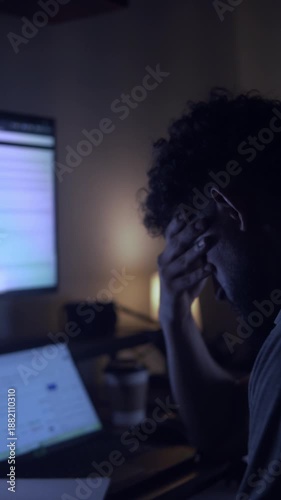 Stressed man experiencing burnout working late at night on computer