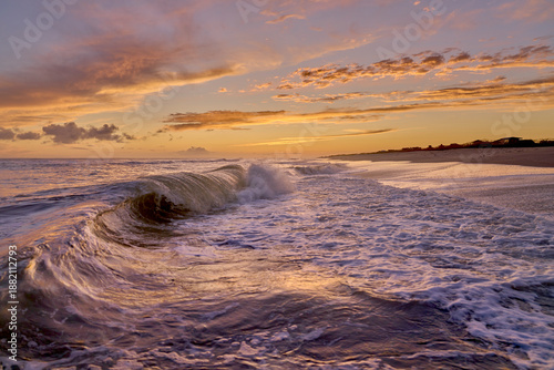 Ocean waves crash along empty beach