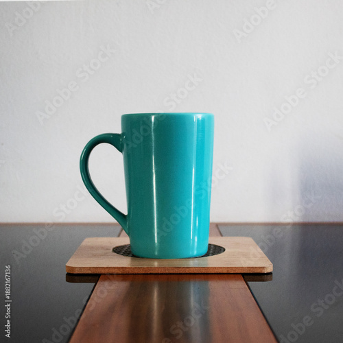 Green cup on a board on the table