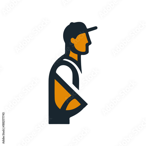 Side profile of a man in a cap, casually standing with arms crossed, urban backdrop