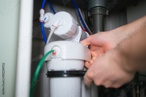Tableau sur toile Hands installing new filter cartridge in an under sink reverse osmosis drinking