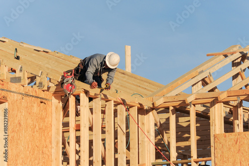 Картината върху платно Construction worker installing wood framing on a residential structure under con