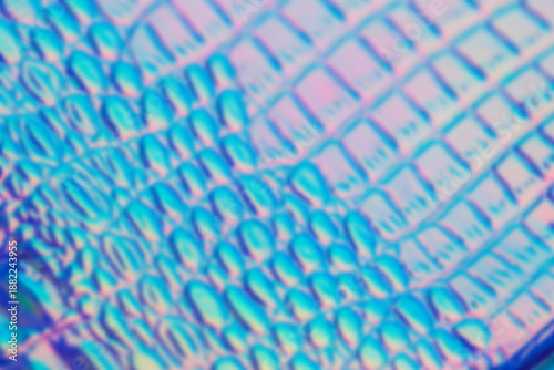 Vivid closeup of an iridescent blurred grid pattern with blue and pink hues. ...