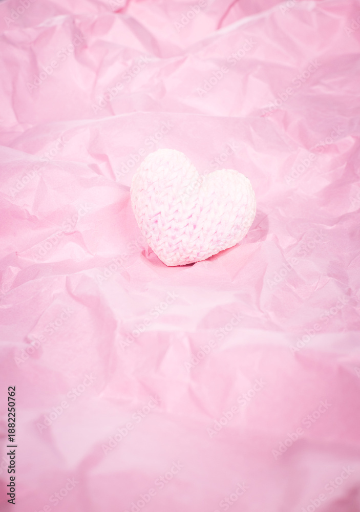 Obraz premium Knitted marshmallow heart on a pink background for Valentine's Day