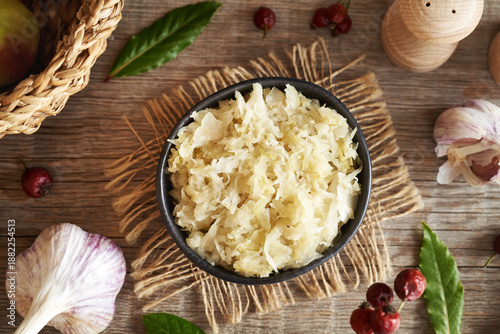 Photos Sauerkraut or fermented cabbage in a bowl on a table, top view