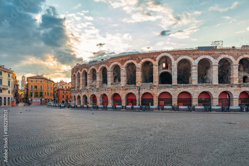 Ancient Roman amphitheater Arena di Verona at sunrise with colorful buildings and empty cobblestone Piazza Bra square, Verona old town, Veneto, Italy. Roman architecture. Italian travel destination