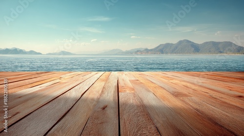 Serene lake view with wooden deck and mountainous horizon.