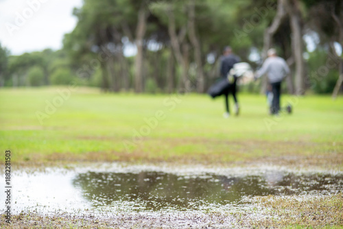 A man and a woman are walking on a golf course