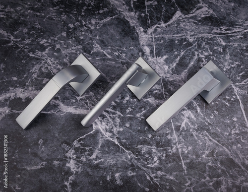Canvas Print Modern interior door handles with chrome finish displayed on marble texture background