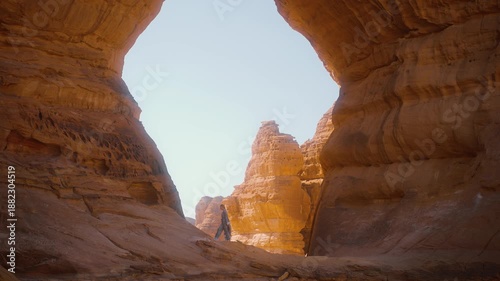 Traveling in AlUla in Saudi Arabia, woman tourist is walking among the sand rocks. Solo traveler in Al Ula enjoys local nature