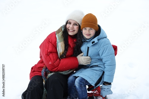 Φωτογραφία Happy mother and her son with sledge outdoors on winter day
