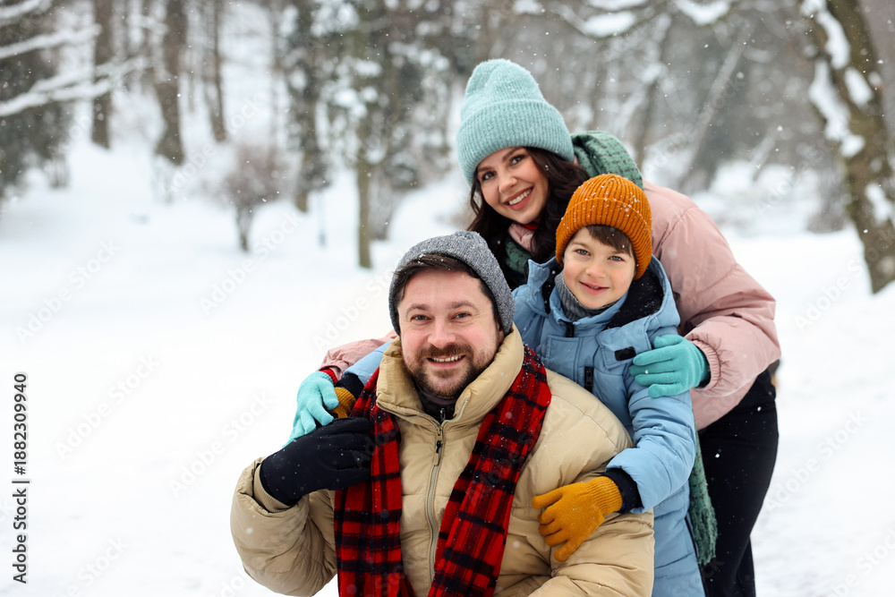 Fototapeta premium Happy family spending time together outdoors on winter day, space for text