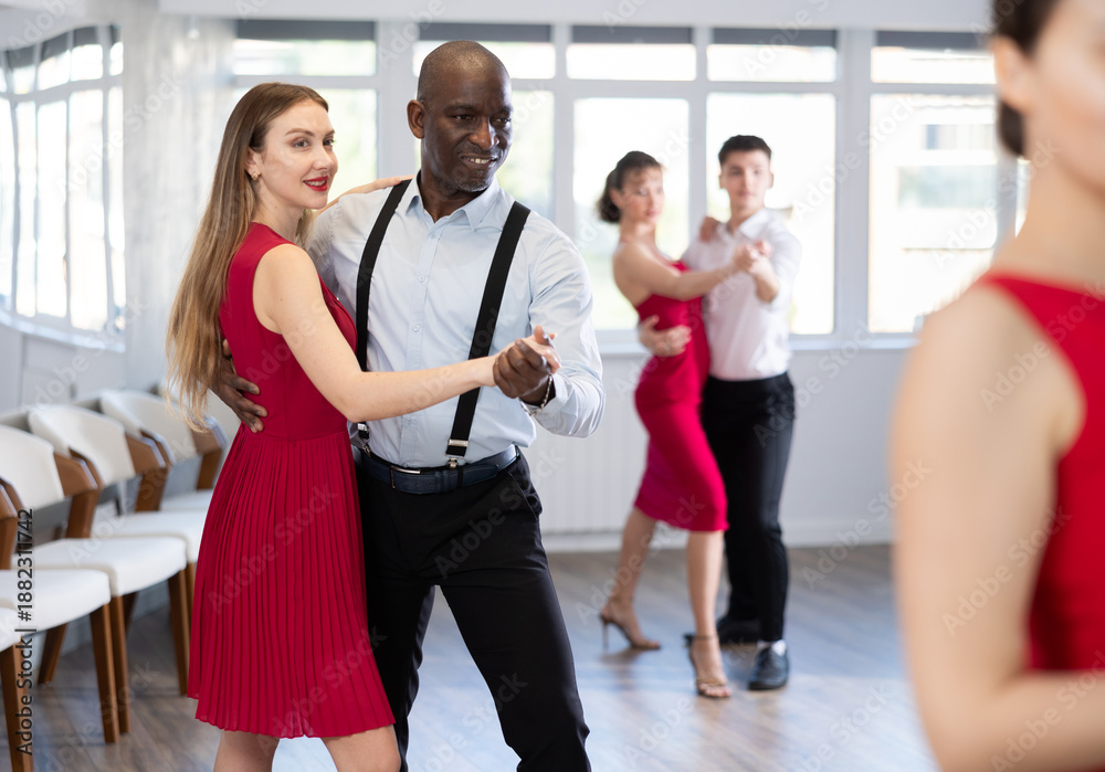 Fototapeta premium Couple of adult man and young woman dancing waltz in studio