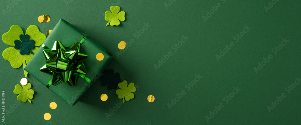 Fototapeta premium A green banner background features a wrapped present with a metallic green bow, shamrock accents, and gold confetti, evoking St Patrick's Day celebration and a warm greeting for holiday campaigns