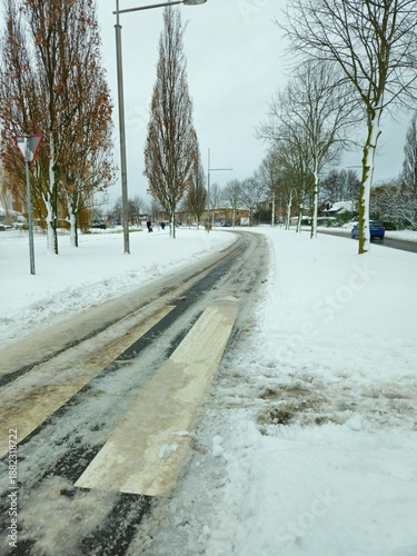 A snowy landscape in the Netherlands. A narrow street of the provincial town after a heavy snowfall. 