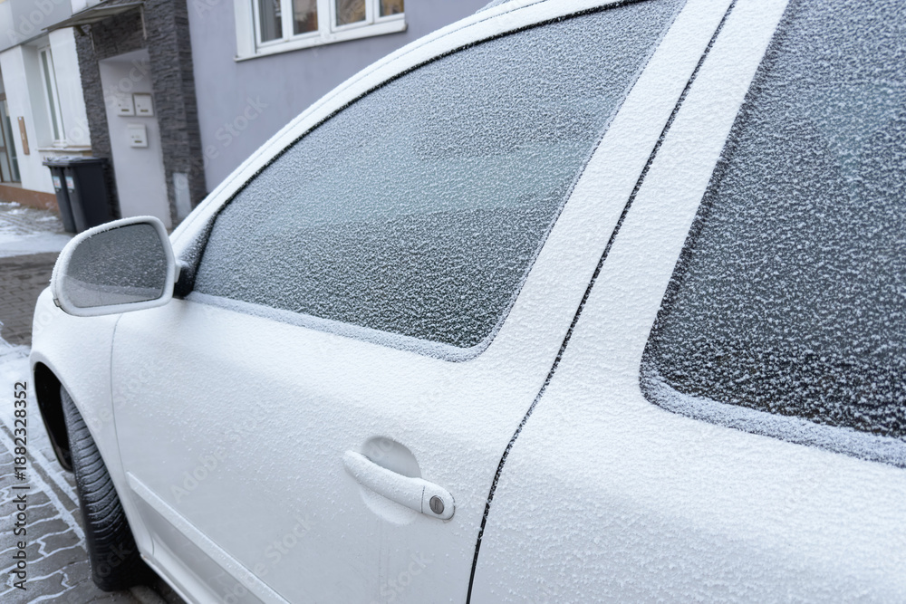 Obraz premium Winter's icy touch blankets a car, its windows veiled in a delicate frost. The world outside blurs behind a crystalline curtain of cold beauty.