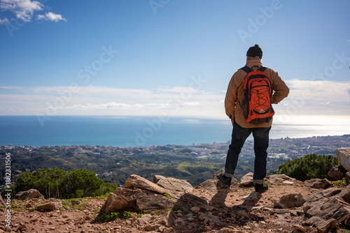 Bilde på lerret Senior man standing on mountain viewpoint overlooking coastal city and sea, enjo