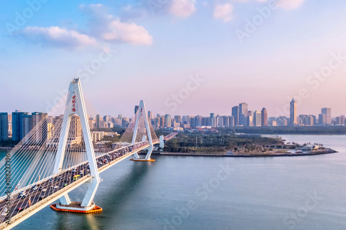 Aerial view of the skyline at dusk over the Haidian River Century Bridge in Haikou, Hainan Island, China.