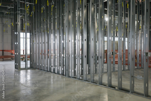 Metal framework standing tall within the expansive interior of a commercial building, capturing the essence of modern construction on a sturdy concrete floor as progress unfolds under bright lights