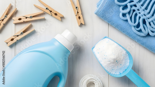 Close-up flat lay of laundry supplies and wooden clothespins | Blue liquid detergent bottle and powdered soap scoop overhead view | Essential household cleaning products for washing clothes