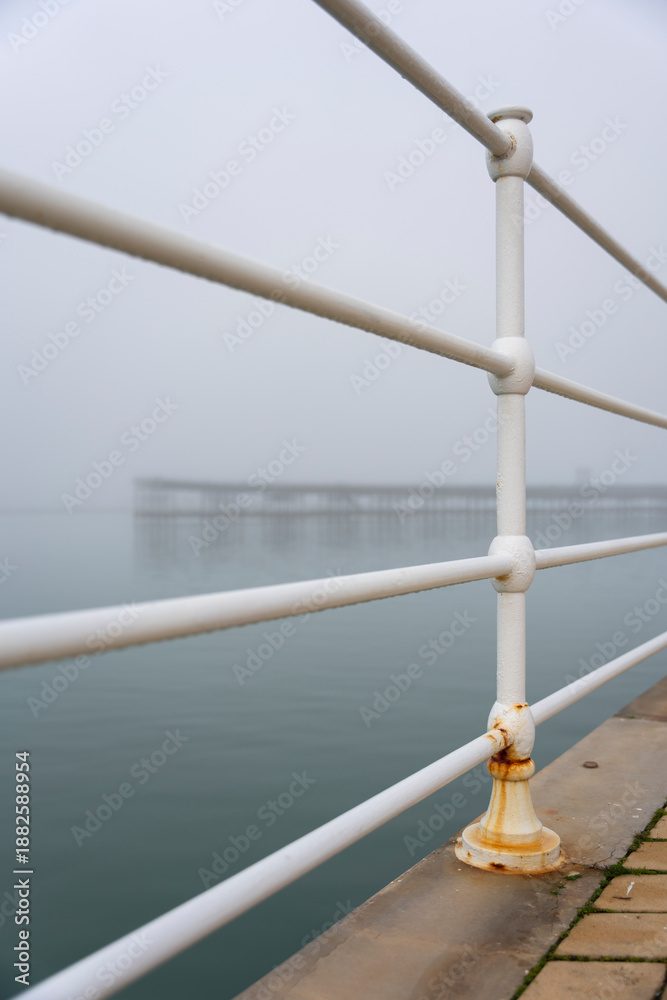Fototapeta premium Fog on the Huelva Estuary. Odiel River. In the background, the old pier of the Tinto mining company. Living history of the city
