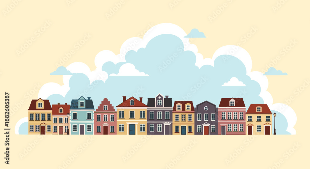 Fototapeta premium Row of charming colorful townhouses with varied architectural styles standing against a background of large blue and white clouds.