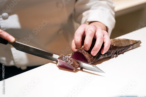Foto 鰹のタタキの刺身を切る