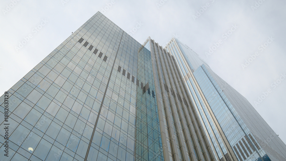 Naklejka premium Tall glass office buildings viewed from ground level perspective