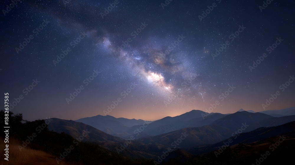 Fototapeta premium A breathtaking view of the Milky Way galaxy arching over a majestic mountain range under a clear night sky