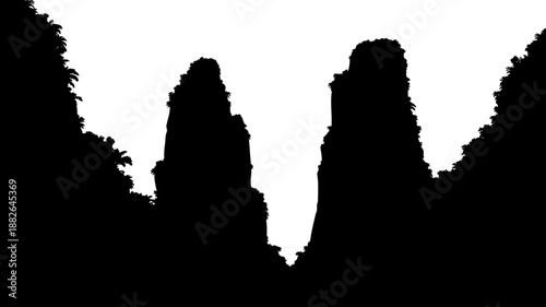 Dramatic mountain peaks silhouette, featuring dense tropical foliage and a narrow valley.