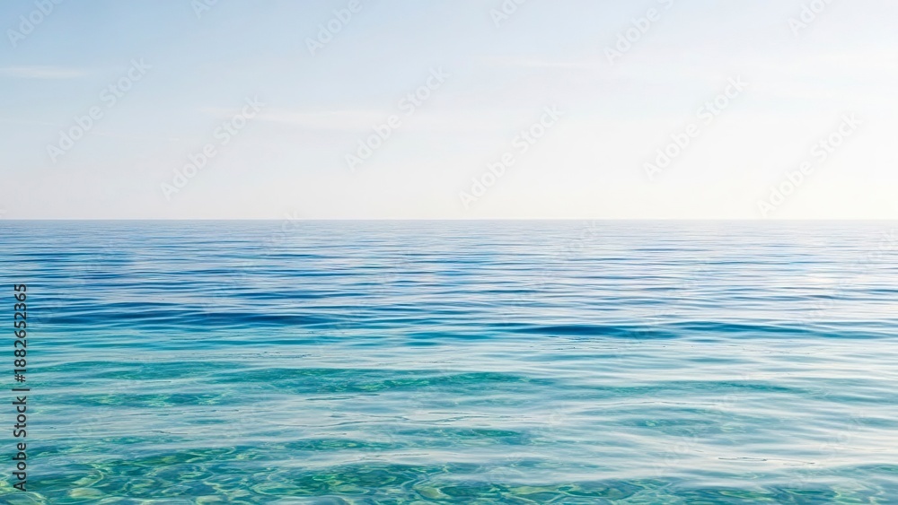 Obraz premium Calm blue sea with visible seabed under clear skies reflecting light