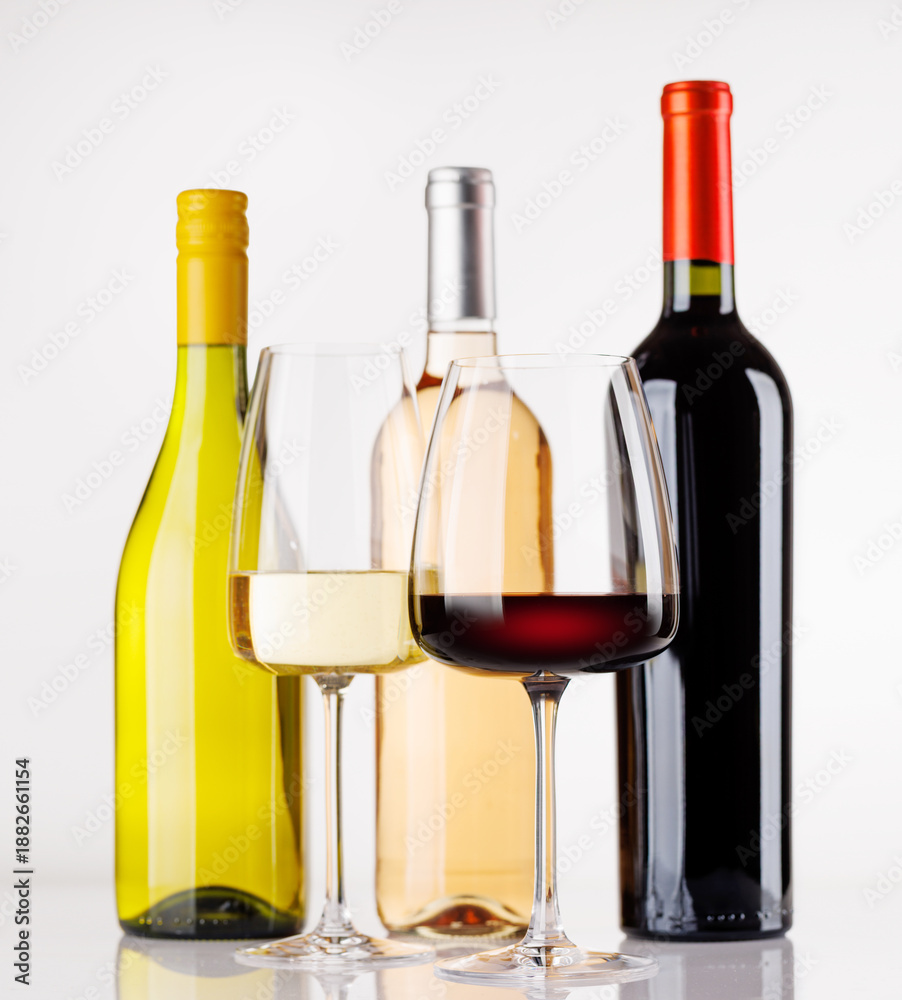 Obraz premium Different wine bottles and glasses on white background