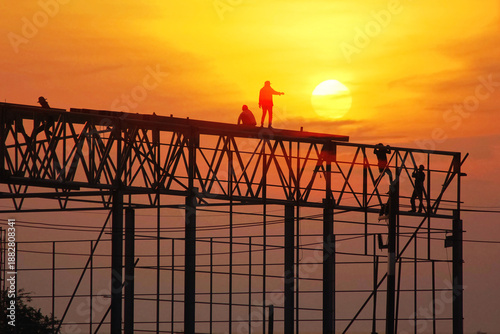 group of worker work late wilding steel structure in construction site on sun set abstract nature background