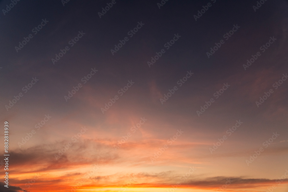 Fototapeta premium Beautiful bright orange sunset sky with clouds.