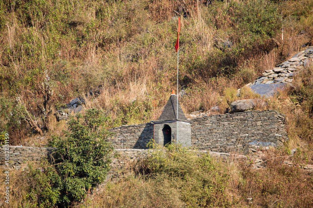 Obraz premium Ancient structure at a hillside location with a flag flying above in daylight