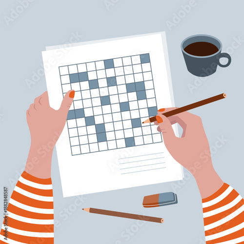 Doing crosswords at the table with a cup of coffee.