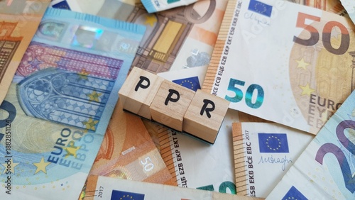 Foto PPR acronym made of wooden letter cubes on pile of Euro banknotes