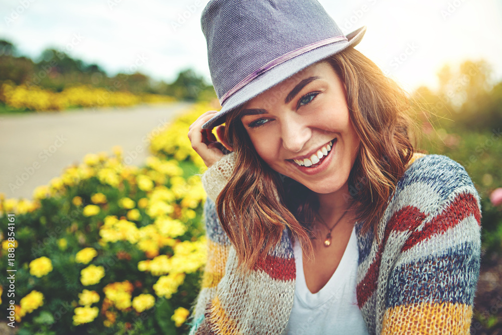 Fototapeta premium Thinking, woman and happy with sunhat outdoor for travel, spring adventure and holiday trip. Smile, female person and sightseeing nature with floral daisies, sunshine or vacation reflection in meadow
