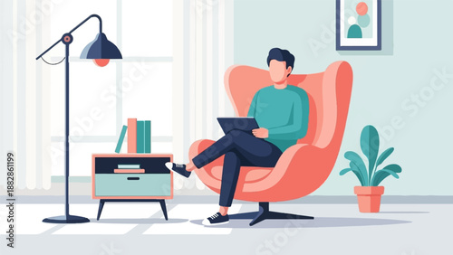 Man relaxing in armchair with tablet, beside a side table with books and floor lamp