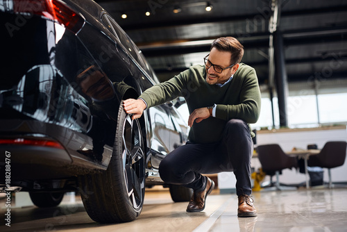 Photos Happy man buying new vehicle at car dealership.
