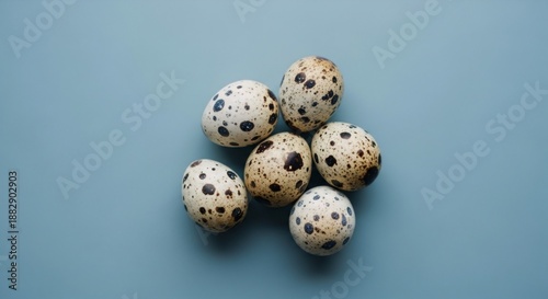 Fresh quail eggs on blue background, minimal food concept