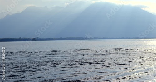 hydrofoil surfer gliding on Lake Geneva against misty Alps mountains