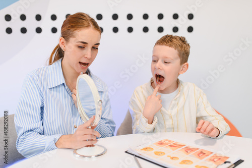 Fotografie Speech therapist teaching child articulation exercises with mirror