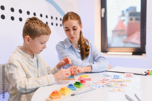 Slika na platnu Child learning geometry with female speech therapist