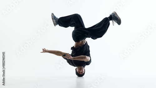 Fotografía Breakdance head supported freeze with extended limbs isolated on white background